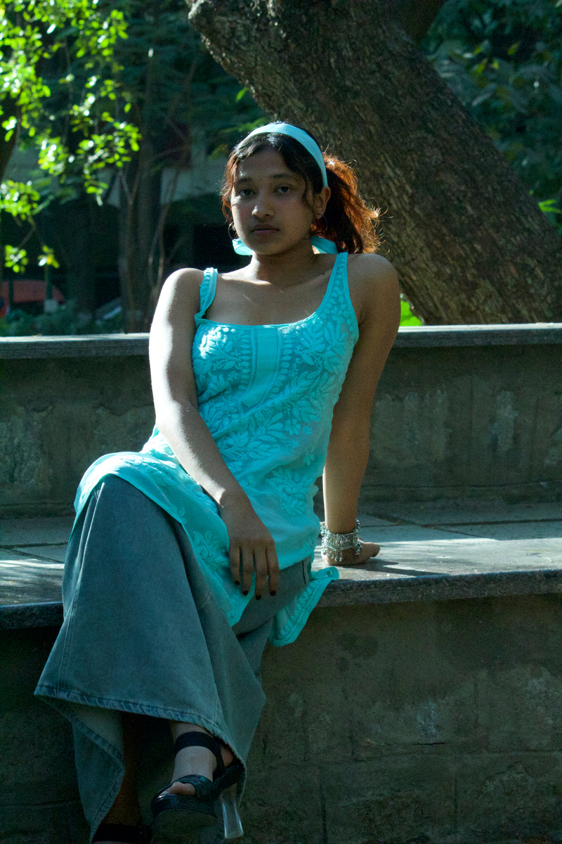 Front view of a model wearing an IT girl aesthetic green Chikankari slip kurti featuring a corset tie-back and matching scarf.